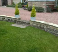 stone driveway with step down to garden