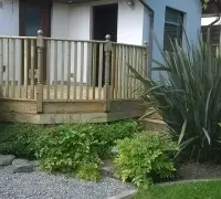 Back garden decking with plants and stone area